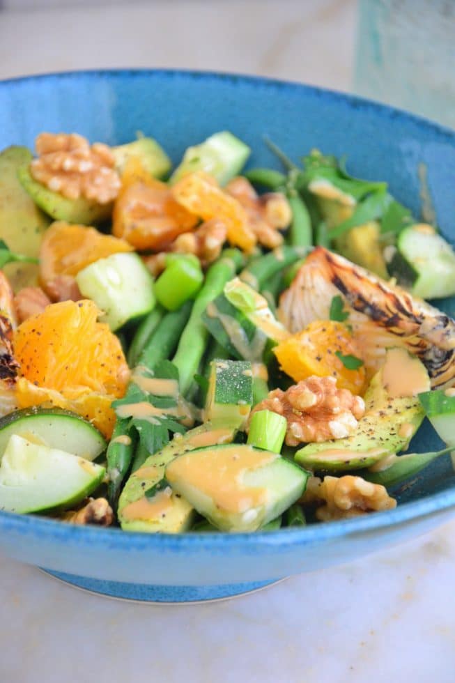 This French Green Bean Salad is gorgeous and loaded with nutrients and fresh vegetables and fruits like cucumbers and oranges in a lovely blue bowl.
