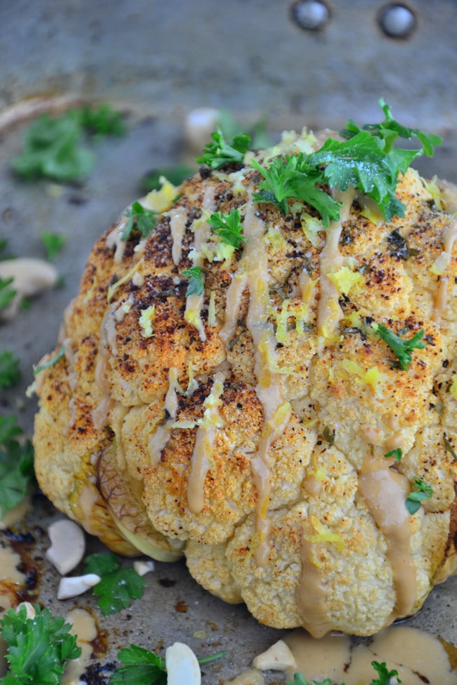 This whole roasted cauliflower recipe is incredible to serve when you're entertaining; it's topped with parsley and fresh lemon zest.