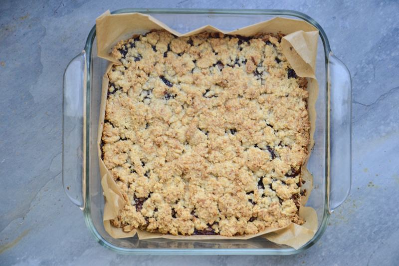 A glass baking sheet filled with uncut fresh baked chewy cherry bars.